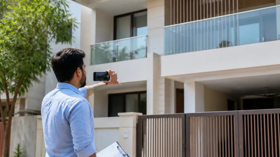Property surveyor photographing a residential building